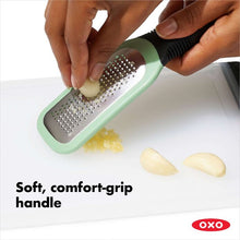Load image into Gallery viewer, OXO Good Grips Etched Ginger & Garlic Grater - Mint Green, in use.