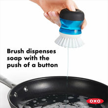 Load image into Gallery viewer, OXO Good Grips Soap Dispensing Palm Brush - Black/White, in use.