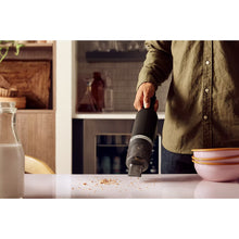 Load image into Gallery viewer, Lifestyle image of KitchenAid Go Cordless Handheld Kitchen Vacuum without Battery - Matt Black.