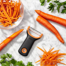 Load image into Gallery viewer, Lifestyle image of OXO Julienne Prep Y-Peeler - Black/ Orange.
