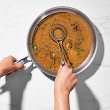 Load image into Gallery viewer, lifestyle image of OXO Good Grips Sauce &amp; Gravy Flat Whisk - Stainless Steel.
