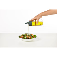 Load image into Gallery viewer, Lekue Oil and Vinegar Glass Dispenser - 1 piece, in use.
