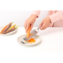 Load image into Gallery viewer, Lifestyle image of Brabantia Profile Coarse Grater - Matt Steel, in use.
